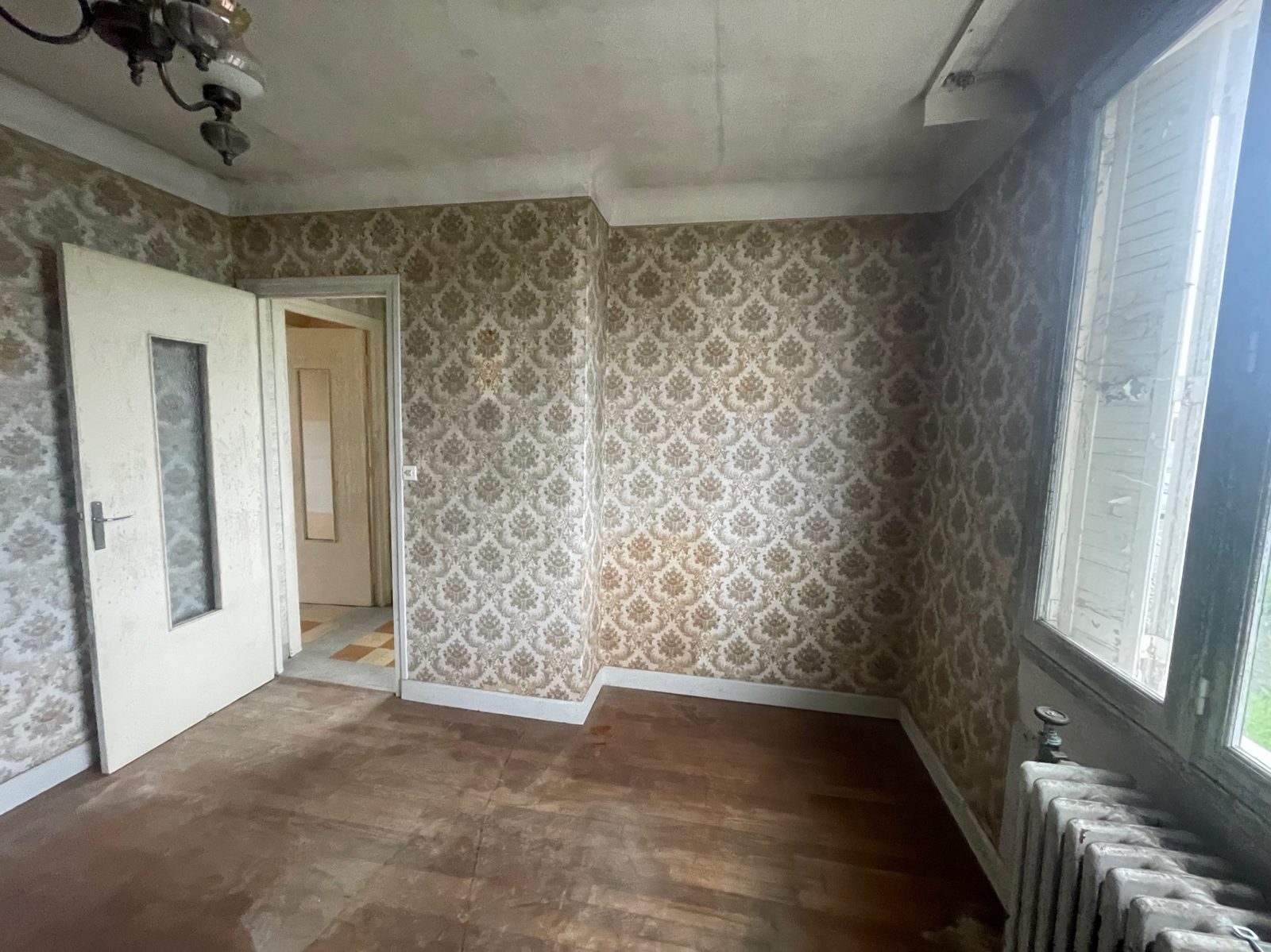Rénovation d'une maison locative à Villiers-Saint-Georges près de Provins - chambre avec papier peint ancien et sol fatigué avant travaux