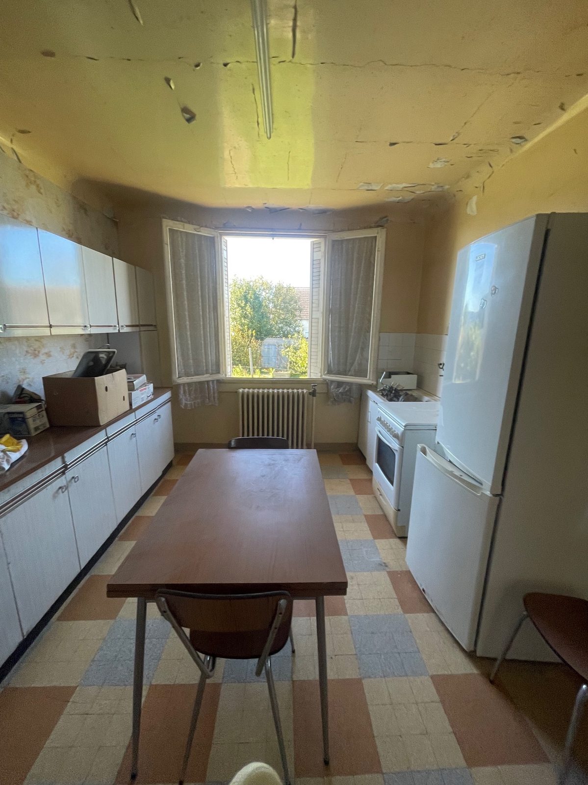 Rénovation d'une maison locative à Villiers-Saint-Georges près de Provins - cuisine vétuste avant travaux, carrelage damier et chauffage fioul