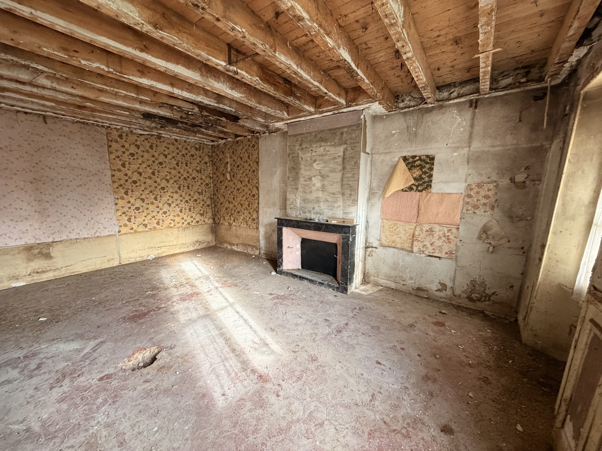 Pièce ancienne avec cheminée et solives avant la rénovation d'une longère à Chalmaison